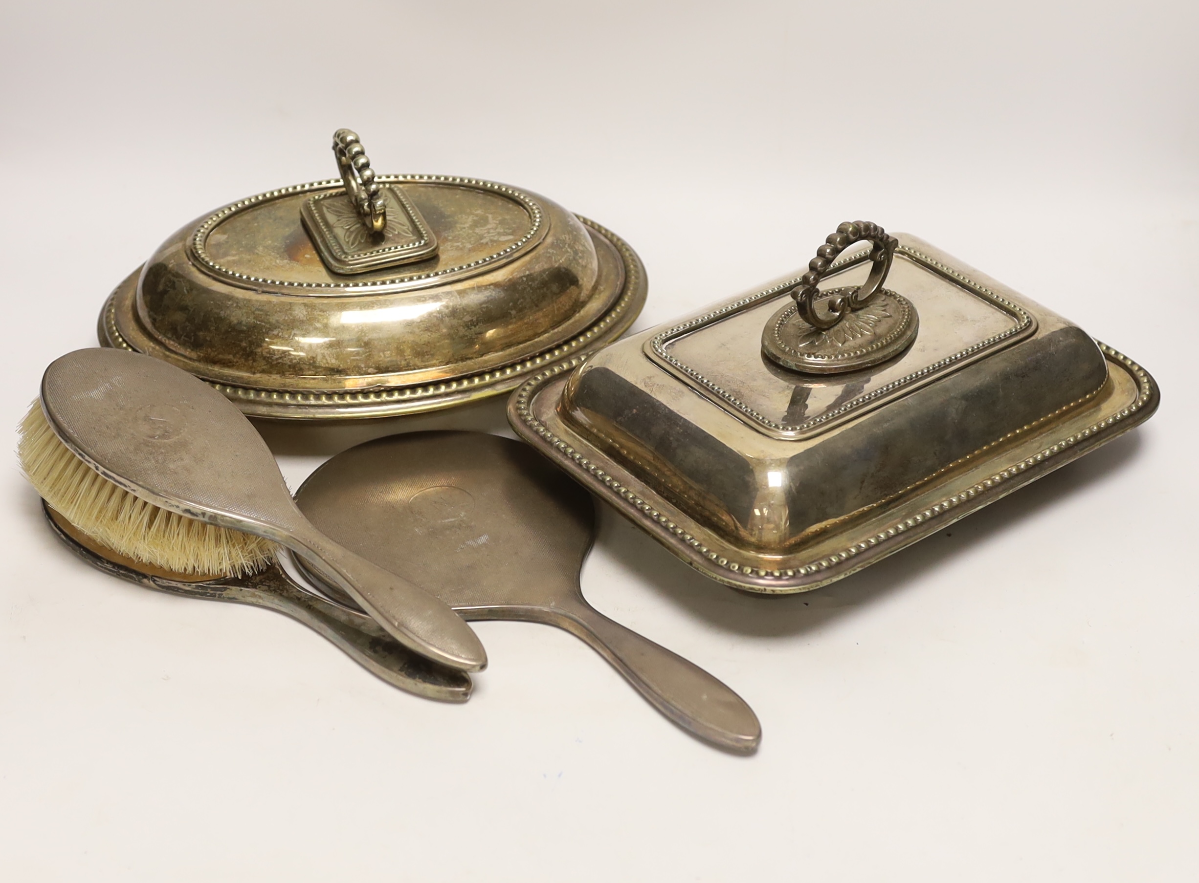 Three plated entrée dishes and a silver dressing table set